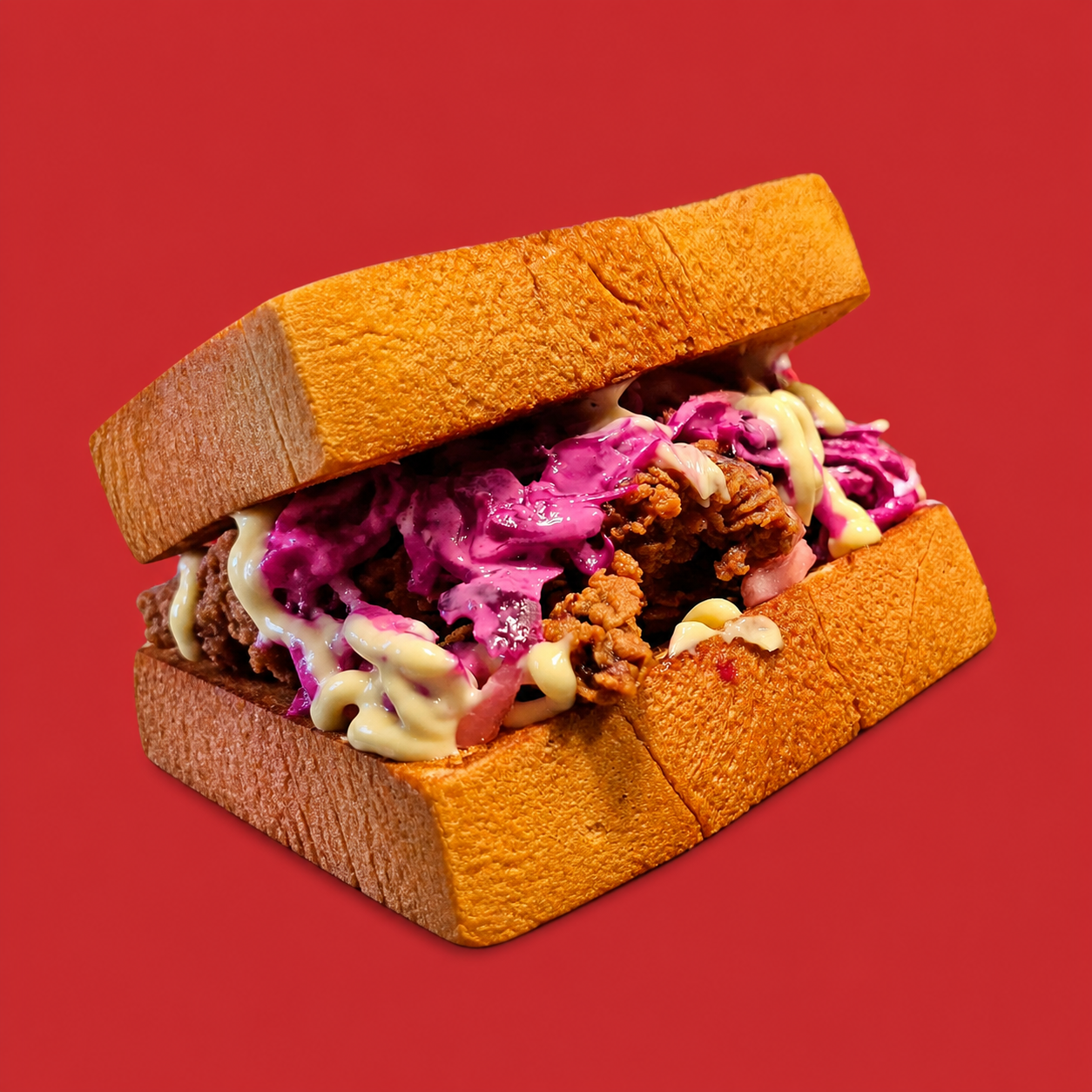 Whole Sweet Chick fried chicken sando with bright pink cabbage and sauce